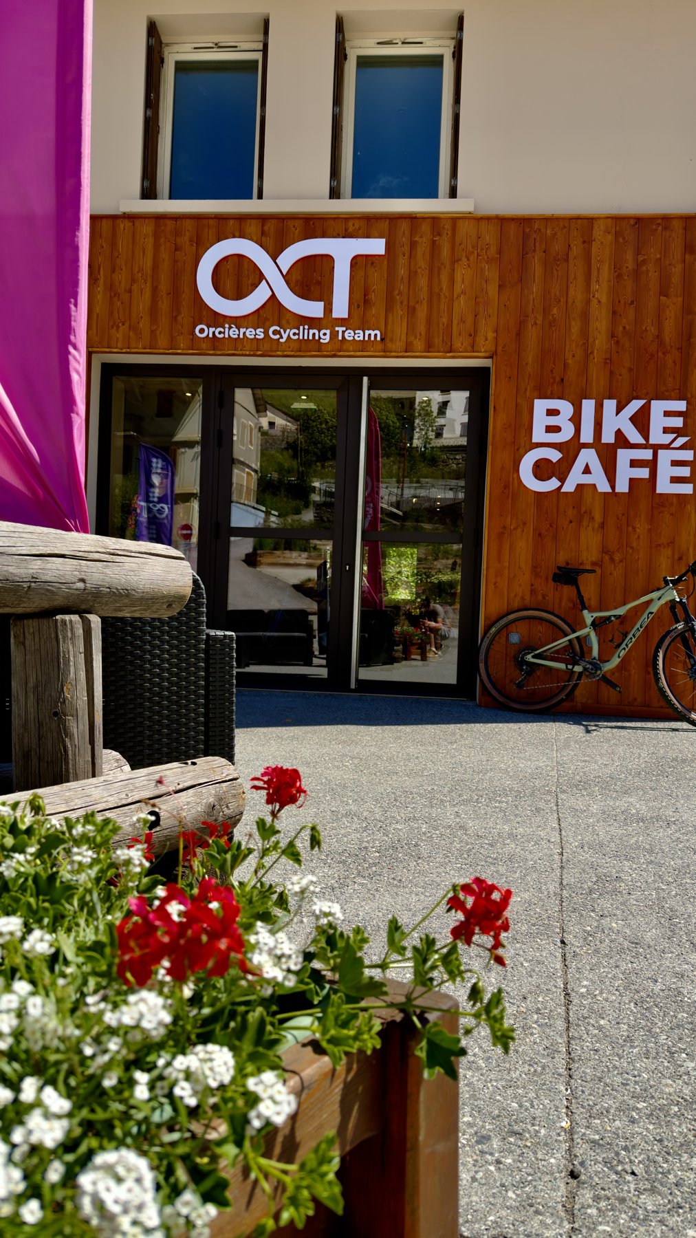 L’entrée fleurie du Bike Café et sa façade en bois