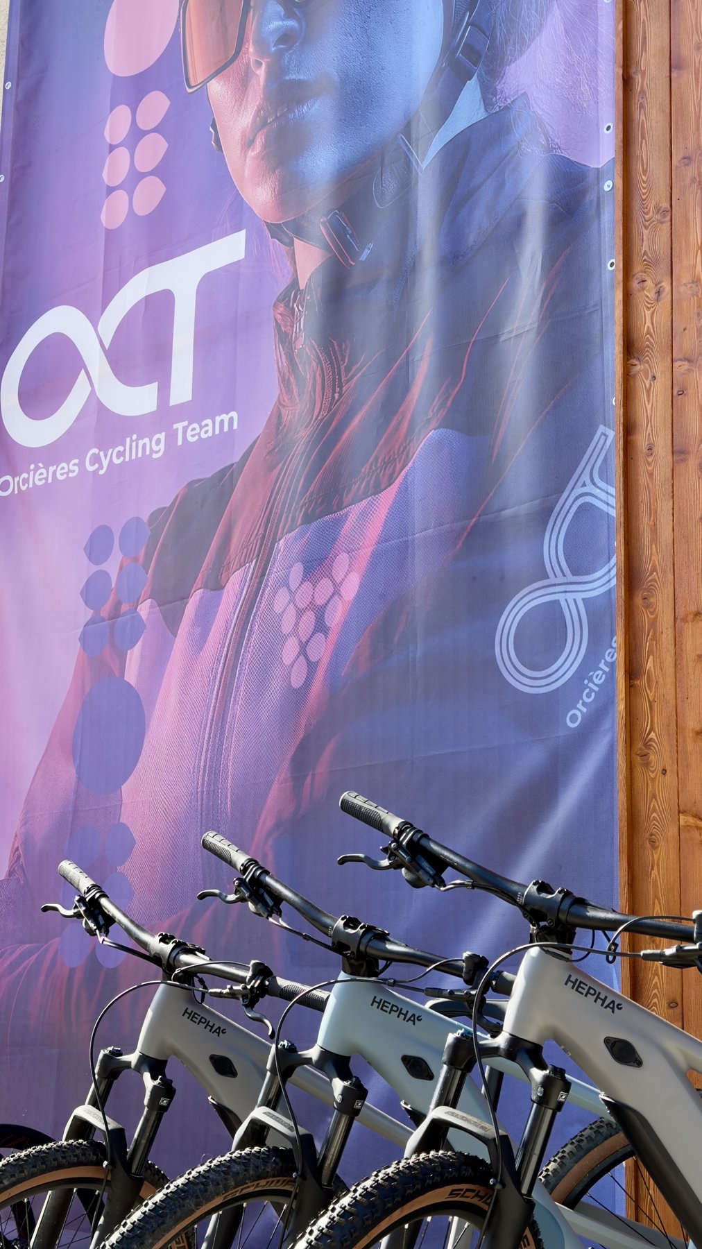 Des VTT devant la grande bannière Orcières Cycling Team